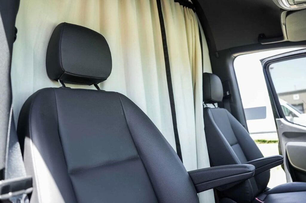Black leather front seats inside a rental van.
