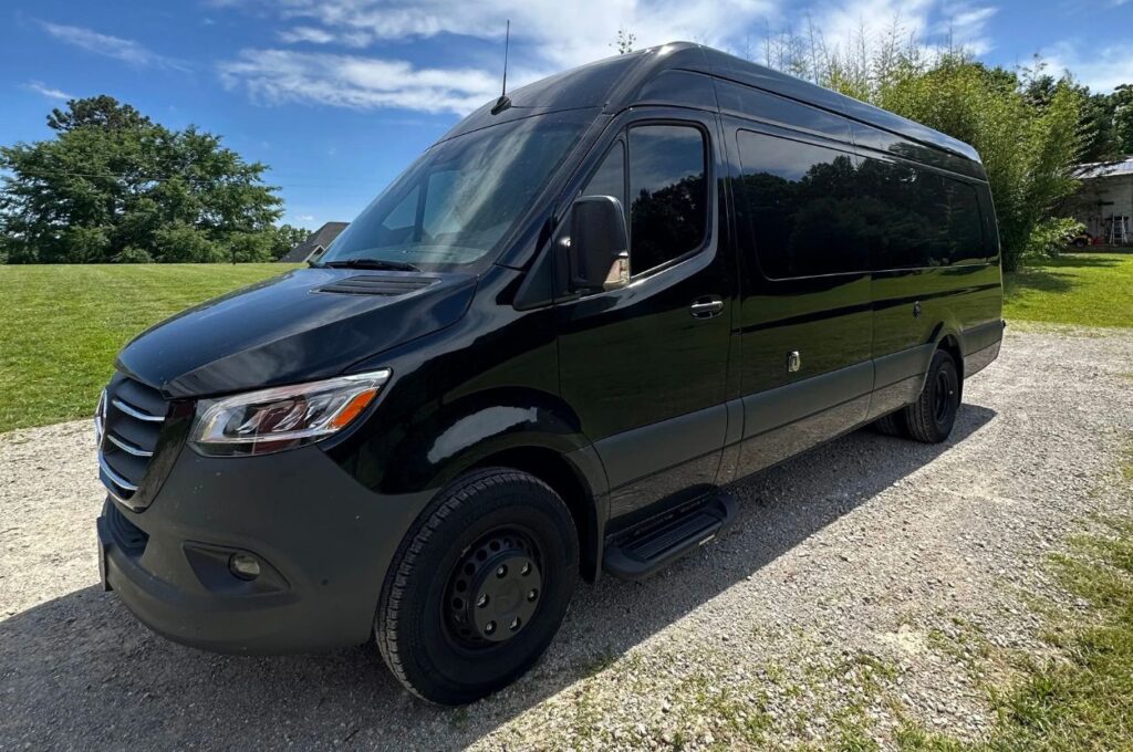 Black Mercedes-Benz Sprinter camper van parked outside.