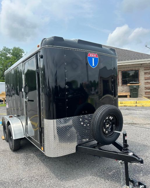 Black enclosed cargo trailer parked outside.