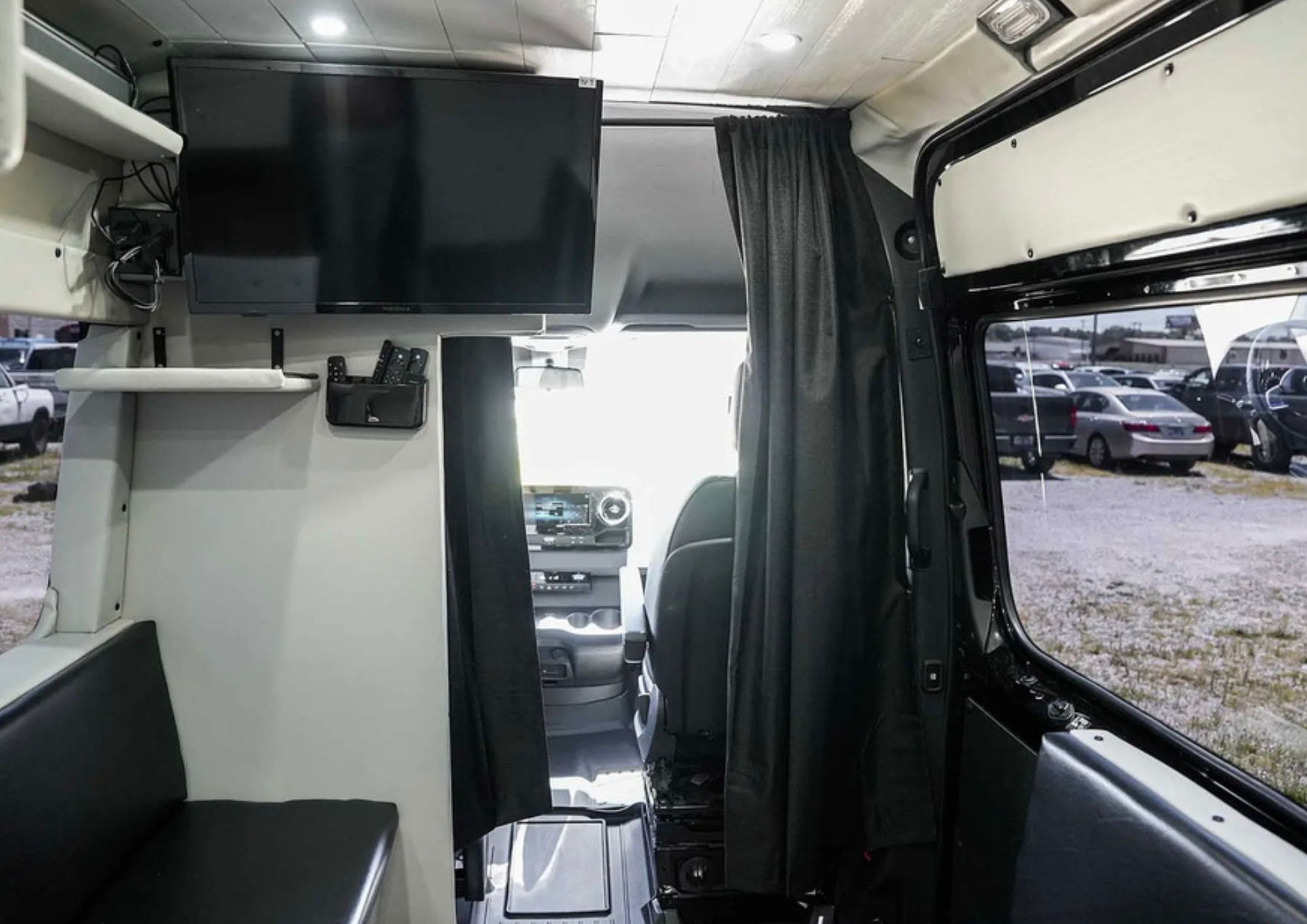 Interior of custom bunk van with mounted television.