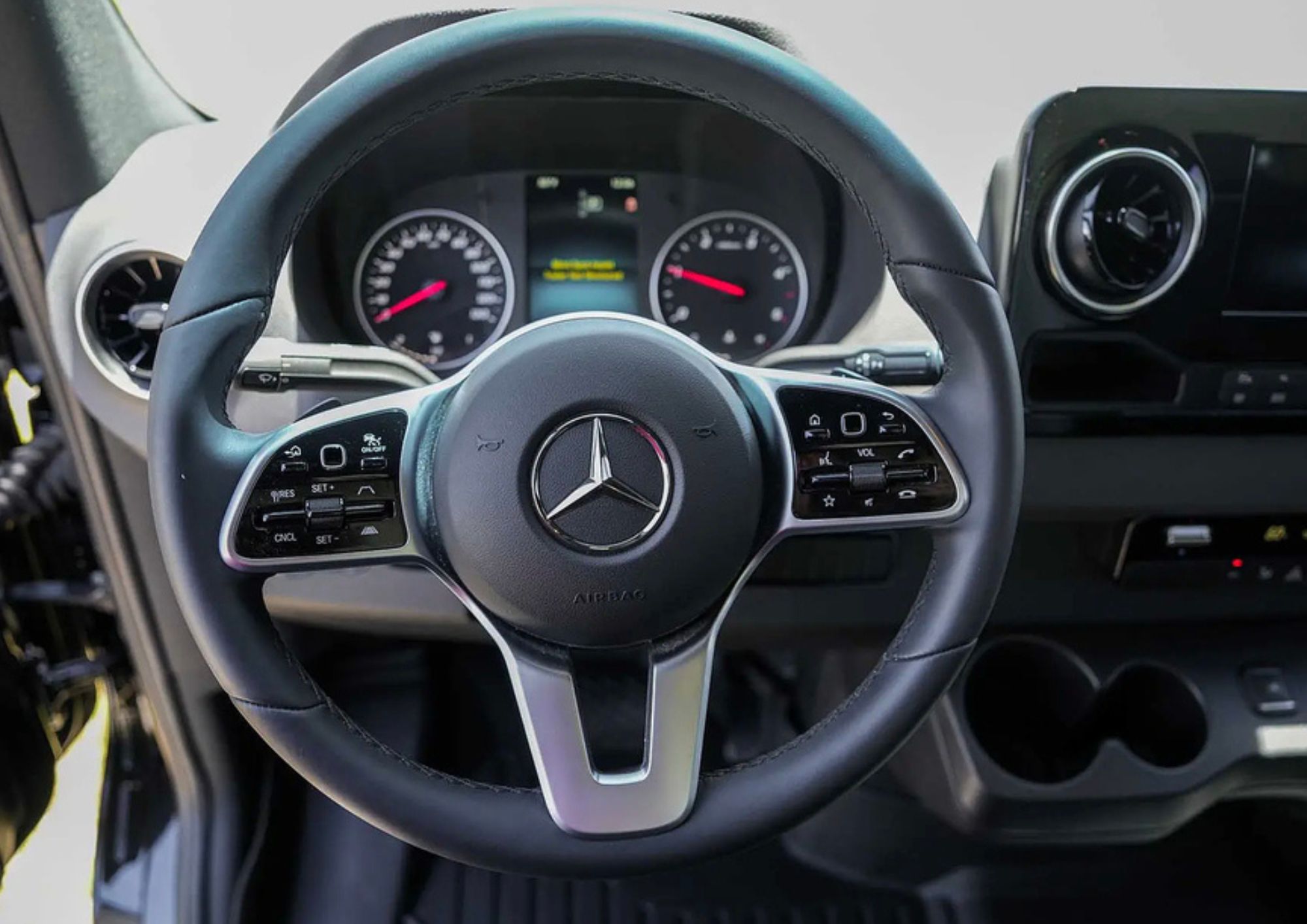 Mercedes-Benz steering wheel and digital dashboard instruments.