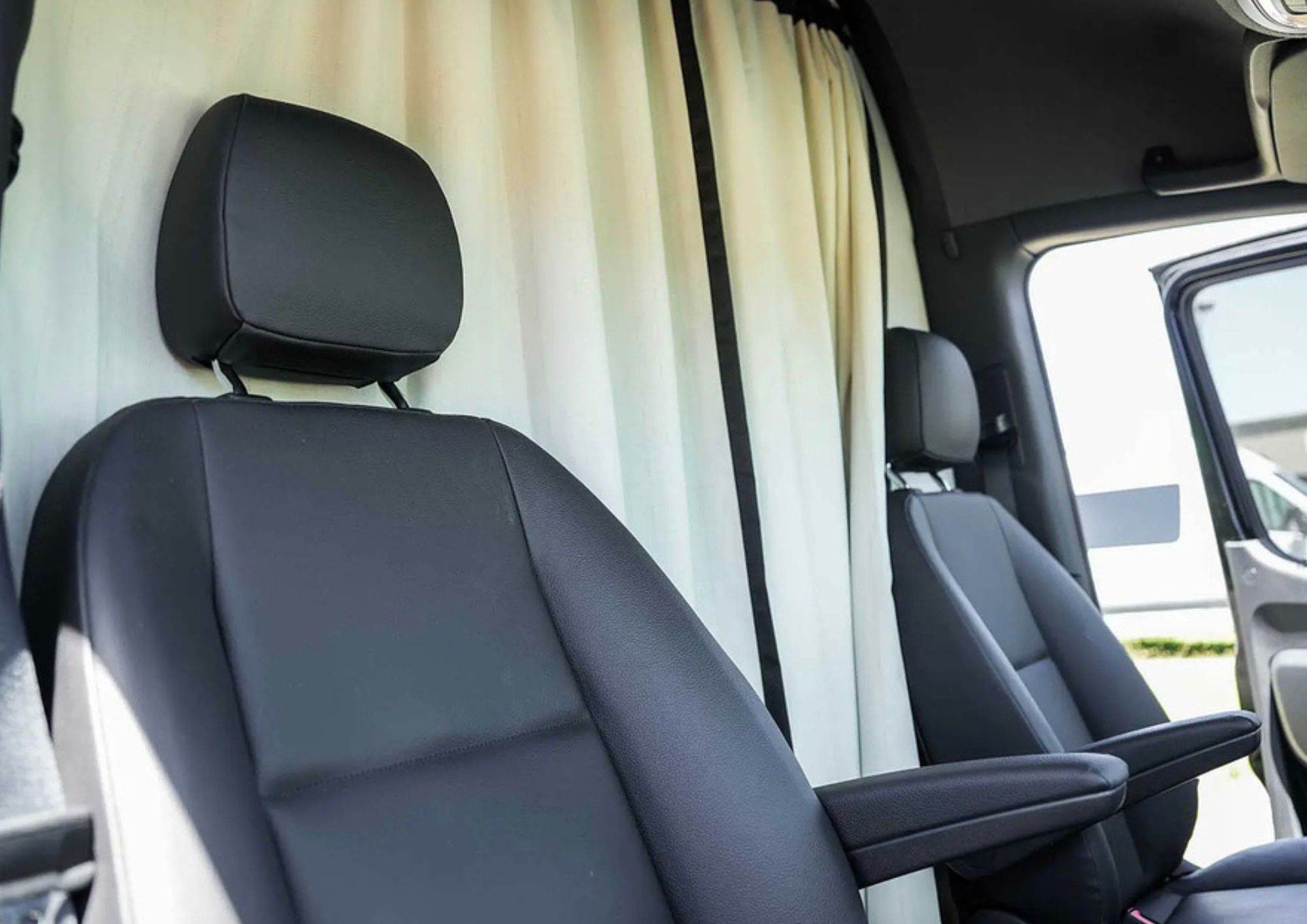 Black leather driver and passenger seats with privacy curtain.